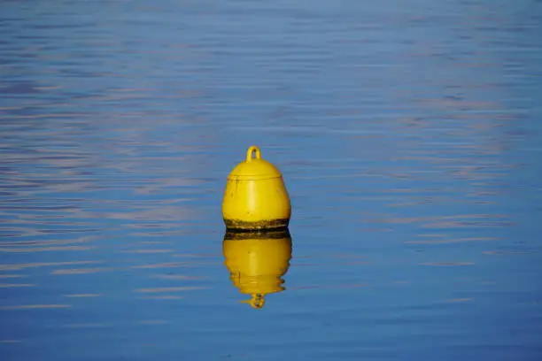 Yellow buoy on blue water surface