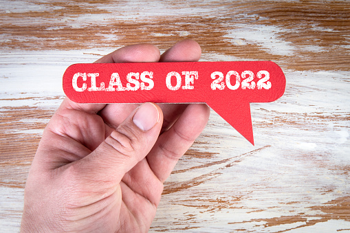 Class of 2022. Red speech bubble with text on a white wooden background.