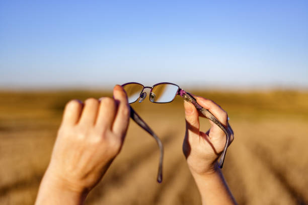 istock Hands hold eyeglasses on defocused sunny field background at sunset. Madrid, Spain 1360506931