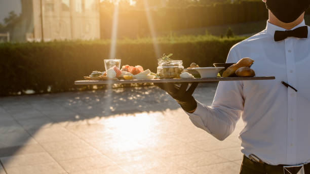 istock waiter holding plates with appetizer in the restaurant. 1360509410