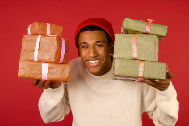 istock A dark-skinned excited young guy with a gift boxes in hands 1360509441