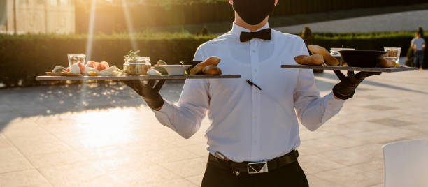 istock waiter holding plates with appetizer in the restaurant. 1360509536