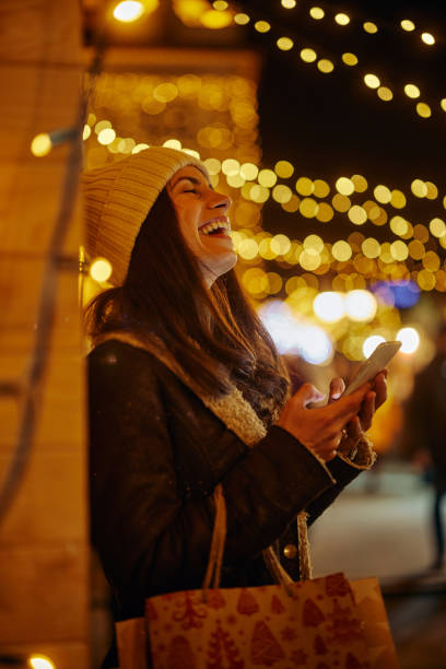 istock Woman on Christmas time using the phone 1360510441