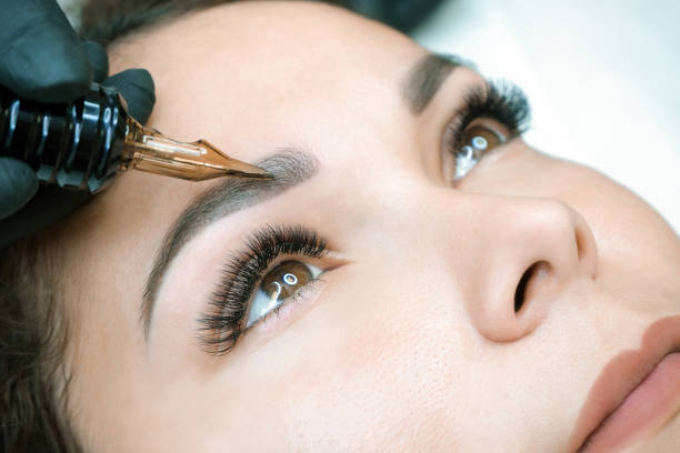 istock Beautician makes permanent eyebrow makeup on the face 1360510492