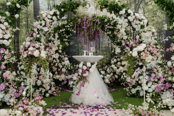 istock Wedding ceremony arch decorated with roses. In the middle is a table with candle composition. 1360510503