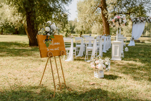 istock Wedding ceremony outdoors in the park. White chairs decorated with roses. 1360510696