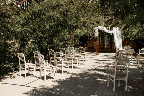 istock Wedding ceremony with chairs and wedding arch from flowers. 1360511487