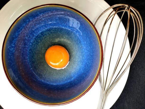 istock Chicken egg yolk and beater. 1360511696