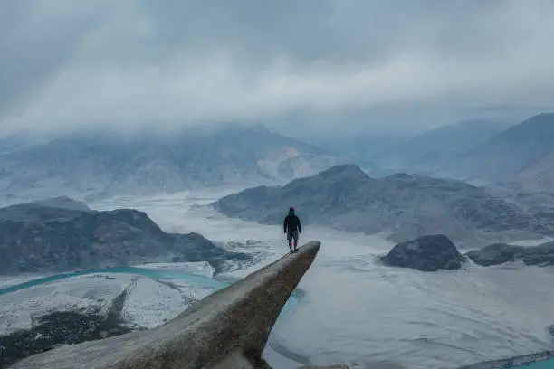 Photo of Aerial view of man standing on rock and looking at river in Himalayas