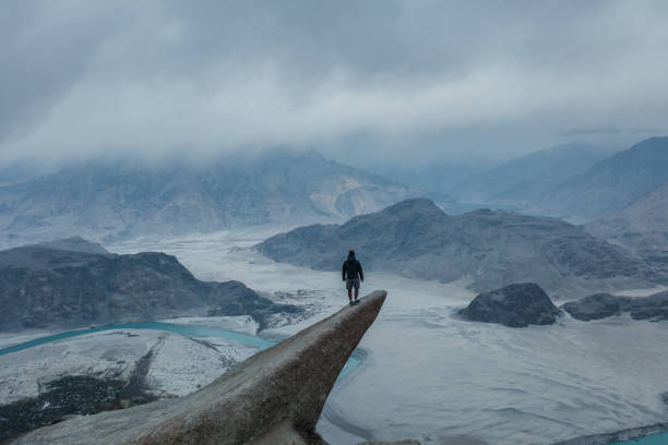 aerial view of man standing on rock and looking at river in himalayas - himalayas mountain aerial view mountain peak imagens e fotografias de stock