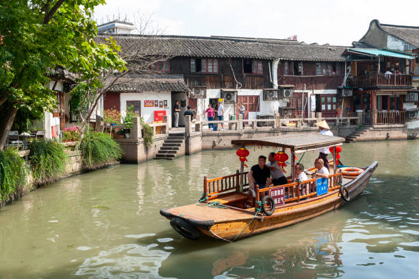 Sightseeing tour on Chinese traditional rowboat along the canal in Zhujiajiao Ancient Water Town, a historic village and famous tourist destination in the Qingpu District of Shanghai, China Shanghai, China - September 2019: Sightseeing tour on Chinese traditional rowboat along the canal in Zhujiajiao Ancient Water Town, a historic village and famous tourist destination in the Qingpu District of Shanghai, China Zhujiajiao stock pictures, royalty-free photos & images