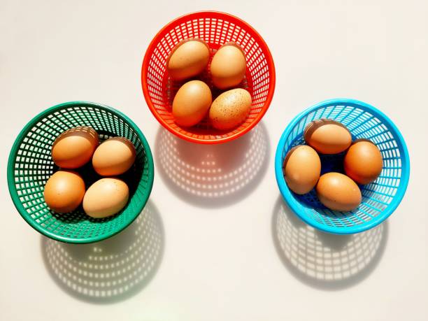 Brown Chicken Eggs in 3 colorful baskets - white background.
