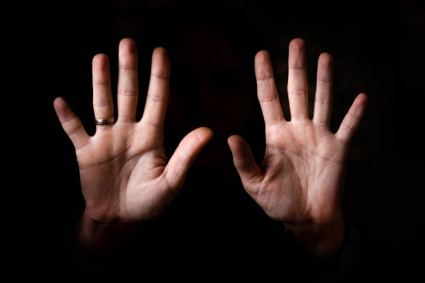 istock female palms aimed at the camera on a black background. 1360518853