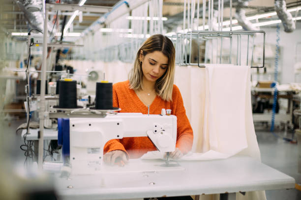 공장에서 전기 재봉틀로 옷을 만드는 젊은 재단사 - sewing textile garment industry 뉴스 사진 이미지