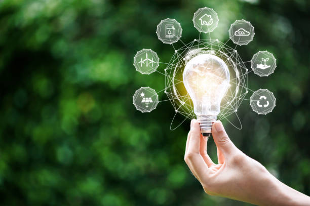 istock Hand holding light bulb with environment Icons over the Network connection on a green background to Technology and environmental protection, renewable, sustainable energy sources. 1360521251