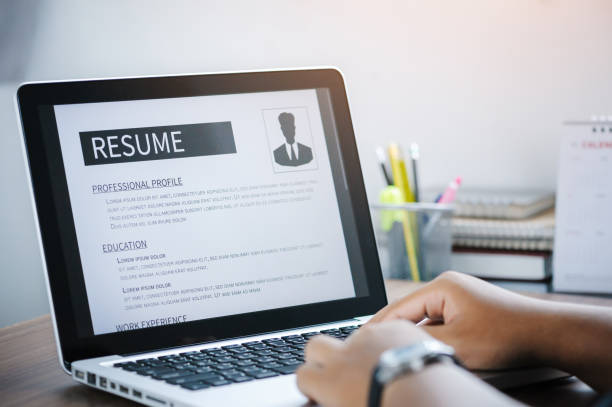 Man writing resume and CV in-home office with laptop. before send for new work and typing curriculum vitae for application. Job seeking, hunt, and unemployment