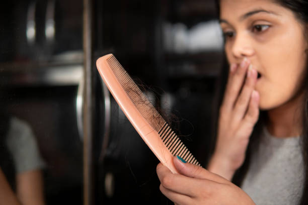 istock Indian woman getting worried about her hair loss problems. 1360521804