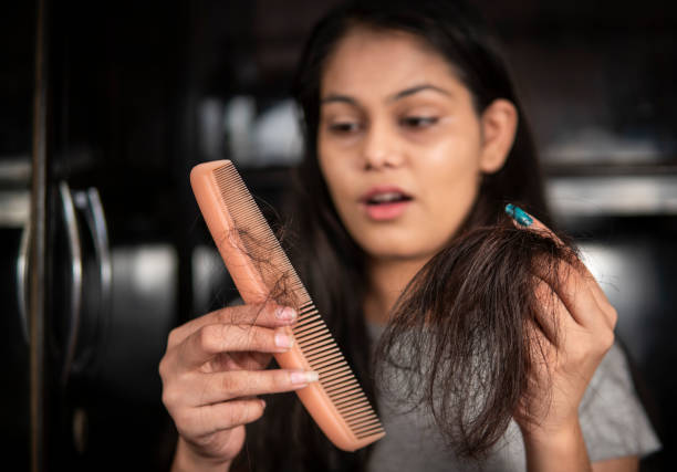 istock Indian woman getting worried about her hair loss problems. 1360521809