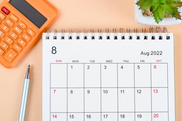 2026 December month calendar and thumbtacks on orange background. Calendar and reminder concept.