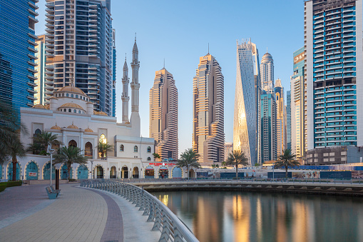 Dubai, UAE - April 22, 2021: Sunset view of Dubai Marina architecture with JBR Mosque on the foreground.