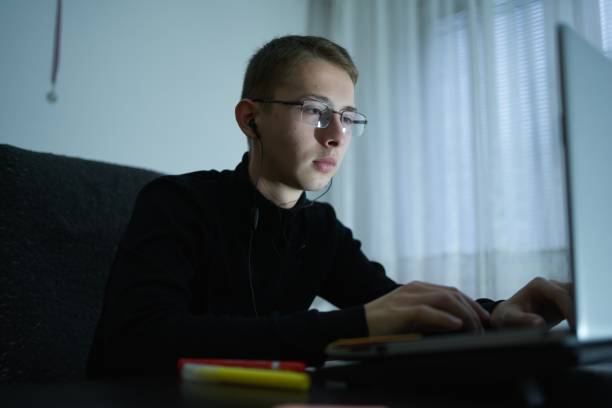 istock Young student working on laptop at dorm room 1360530406