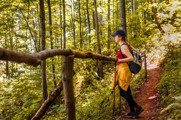 istock Young woman with a backpack going up in the mountain forest 1360531244