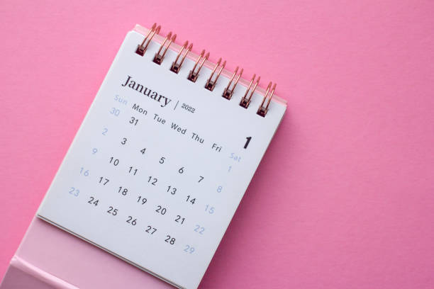 istock Desktop calendar for January 2022 on a pink background. 1360531861
