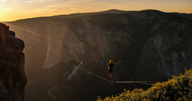 Slack liner - Taft point (2) A slackliner makes a death defying journey across the valley over Taft Point. Taken during sunset in the summer of 2019, Yosemite national park. At over 3000 feet high Taft point makes for an exciting challenge for aspiring daredevils. highlining stock pictures, royalty-free photos & images