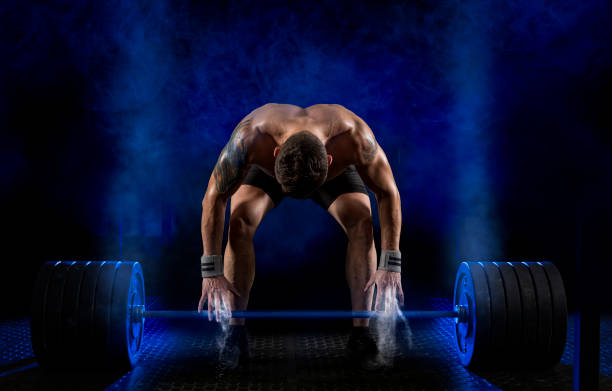 Muscular man working out with barbell Sporty muscular man working out with barbell at a gym powerlifting stock pictures, royalty-free photos & images