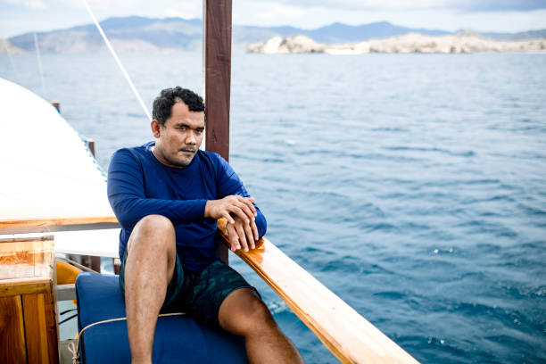 istock asian man sitting on the deck during traveling by ship 1360538793