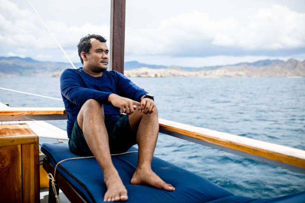 istock asian man sitting on the deck during traveling by ship 1360538797