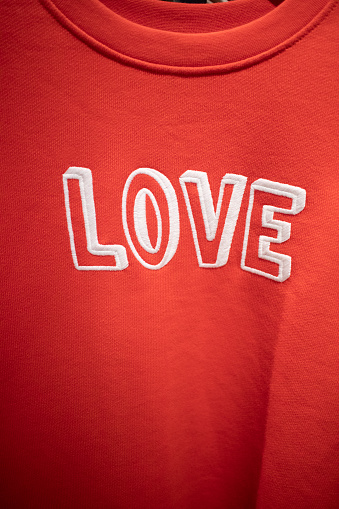 The word 'Love' embroidered on a red sweatshirt