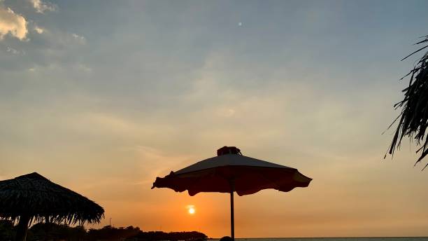 istock Beach umbrella and the sunset view 1360547207