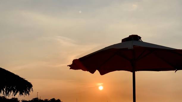 istock Beach umbrella and the sunset view 1360547215