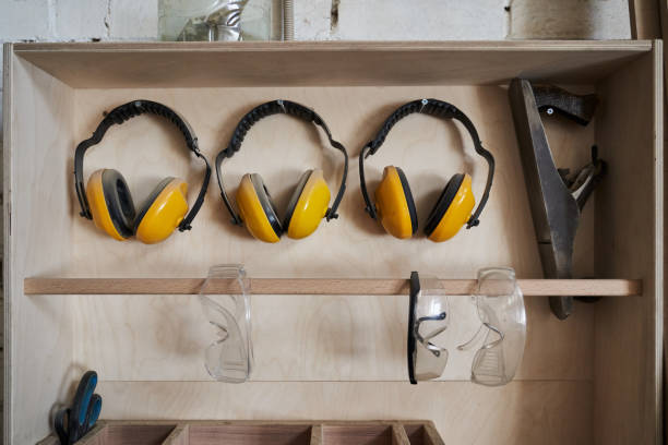 cache-oreilles de protection jaunes et lunettes transparentes pour protéger le travailleur sont suspendus dans le placard - aile vestigiale photos et images de collection