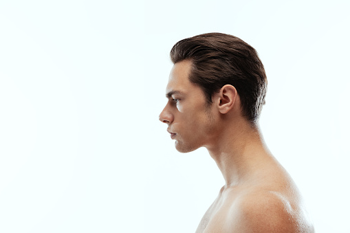 Profile view of young handsome man isolated on white background. Concept of men's health, self-care, body and skin care. Copy space for ad, text, design. Medicine and beauty treatment