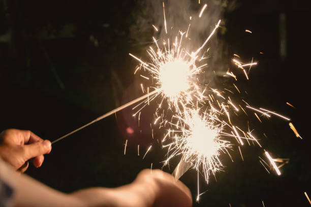 istock Two Friends Lighting Multiple Sparklers on New Year Eve 1360547831