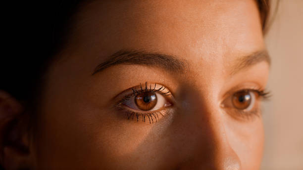 Beautiful woman putting mascara on eyelashes. Close up Female human eye details. Studio shot of woman putting on make up cornea stock pictures, royalty-free photos & images