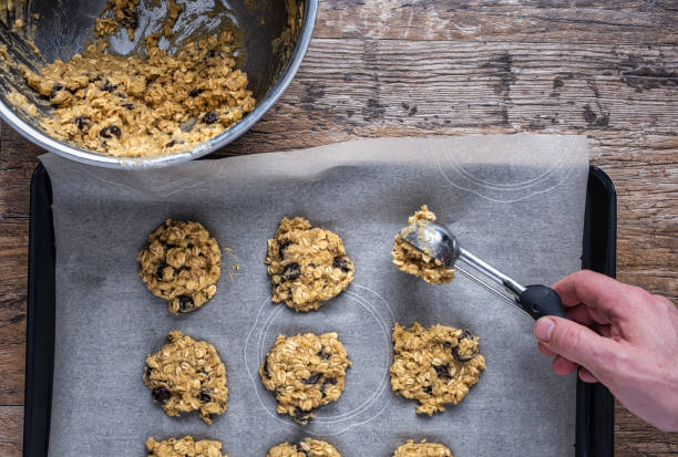 istock Scooping oatmeal cookie dough onto a sheet pan 1360550429