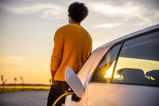 istock Man waiting while his electric car is charged 1360553179