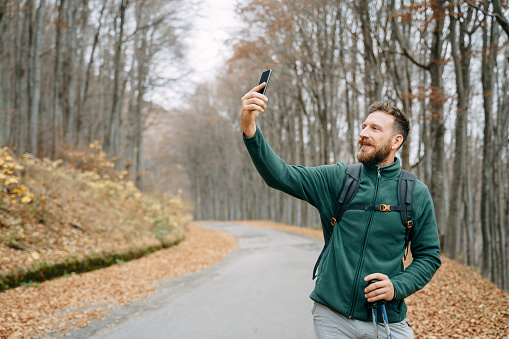 Hiking tourist taking a selfie in the forest