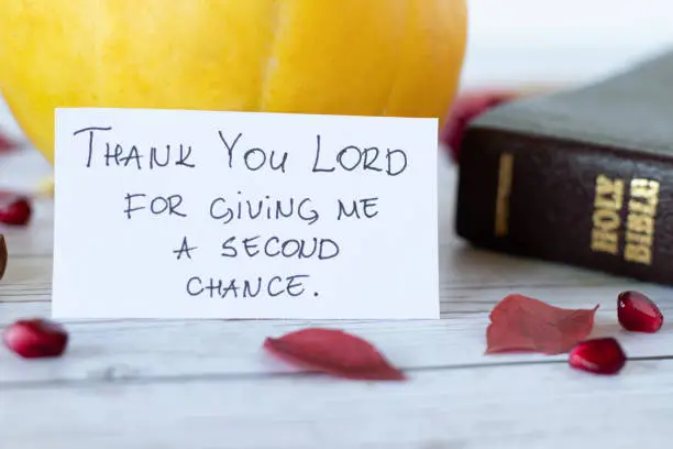 Thank You, Lord, for giving me a second chance. Thanksgiving and gratitude toward God Jesus Christ. Christian biblical concept of thankfulness. Closed Holy Bible Book with a handwritten quote, and fruits.