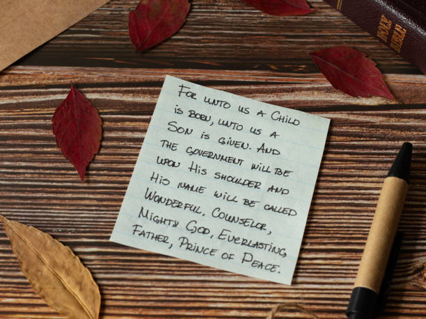 God Jesus Christ birth handwritten Bible verses with red autumn leaves, pen, and old paper on wooden rustic background God Jesus Christ birth handwritten Bible verses with red autumn leaves, pen, and old paper on wooden rustic background. Christian biblical concept. The prophecy of Immanuel from Isaiah the prophet. immanuel stock pictures, royalty-free photos & images