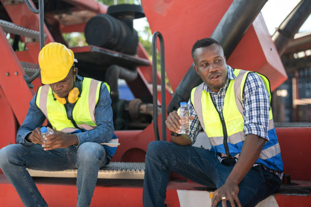 istock African workers, Engineer, Technician sitting and drinking water. people resting after working at the heavy machine vehicle. Concept people operation in heavy industrial. 1360557387