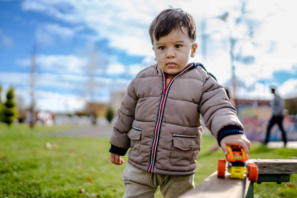 istock Baby boy playing in the park at playground 1360559331