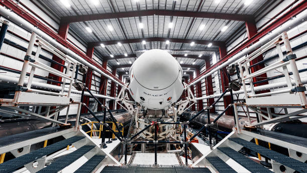 Space launch preparation. Spaceship SpaceX Crew Dragon, atop the Falcon 9 rocket, inside the hangar , just before rollout to the launchpad. Elements of this image furnished by NASA Space launch preparation. Spaceship SpaceX Crew Dragon, atop the Falcon 9 rocket, inside the hangar , just before rollout to the launchpad. Elements of this image furnished by NASA. space travel vehicle stock pictures, royalty-free photos & images