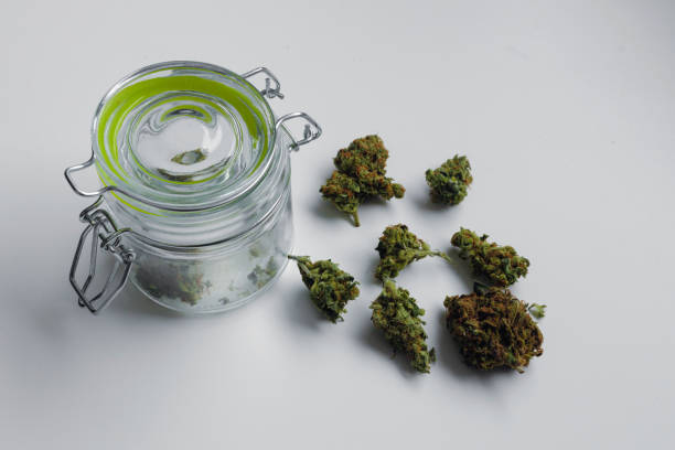 istock Medical marijuana buds taken from a jar on white background 1360562950