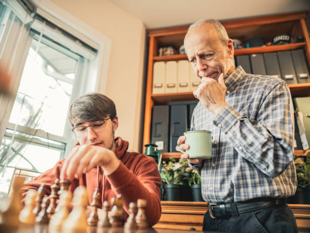 istock Grandfather and Grandson playing chess at home 1360565257