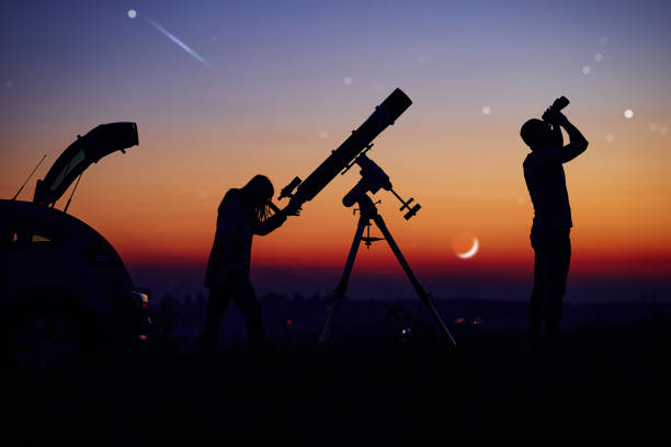 istock Couple stargazing together with a astronomical telescope. 1360566231