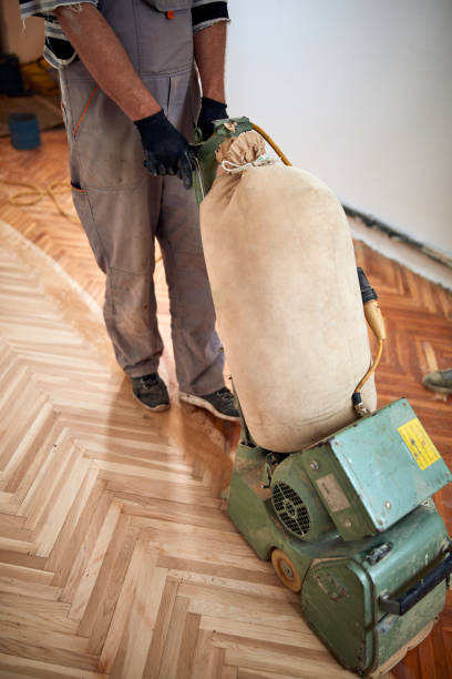 istock Repairman restoring parquet with a sanding machine. 1360566931